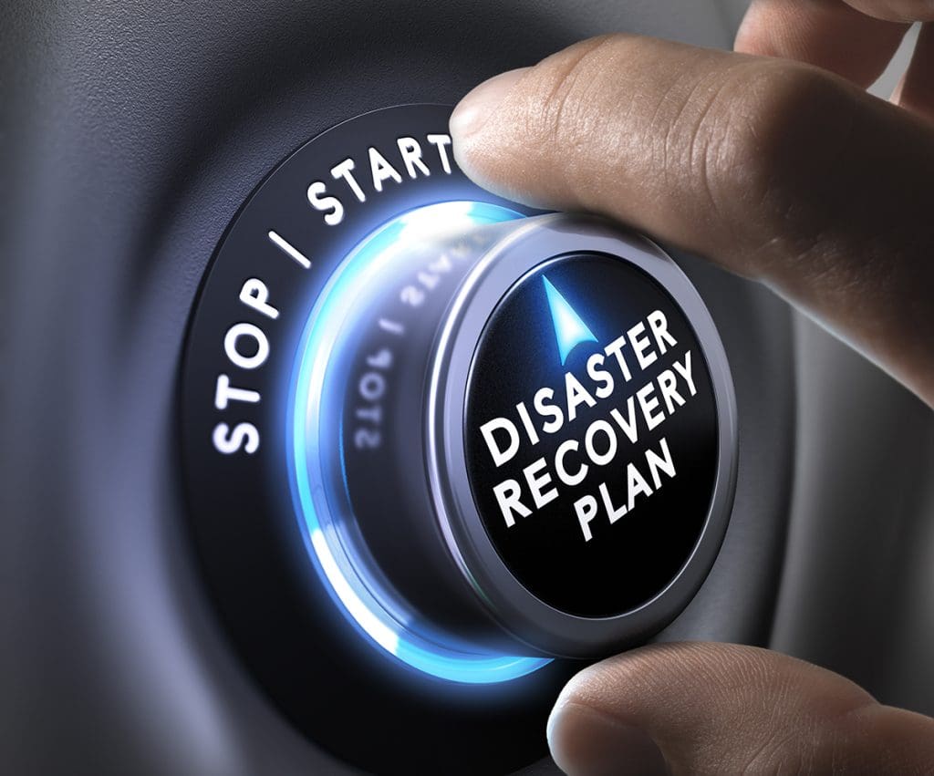 A person turning a dial to start for a disaster recovery plan.