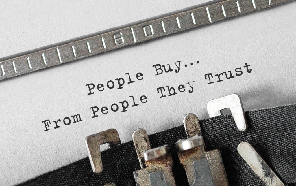 A typewriter that has the message printed “People Buy…From People They Trust.”