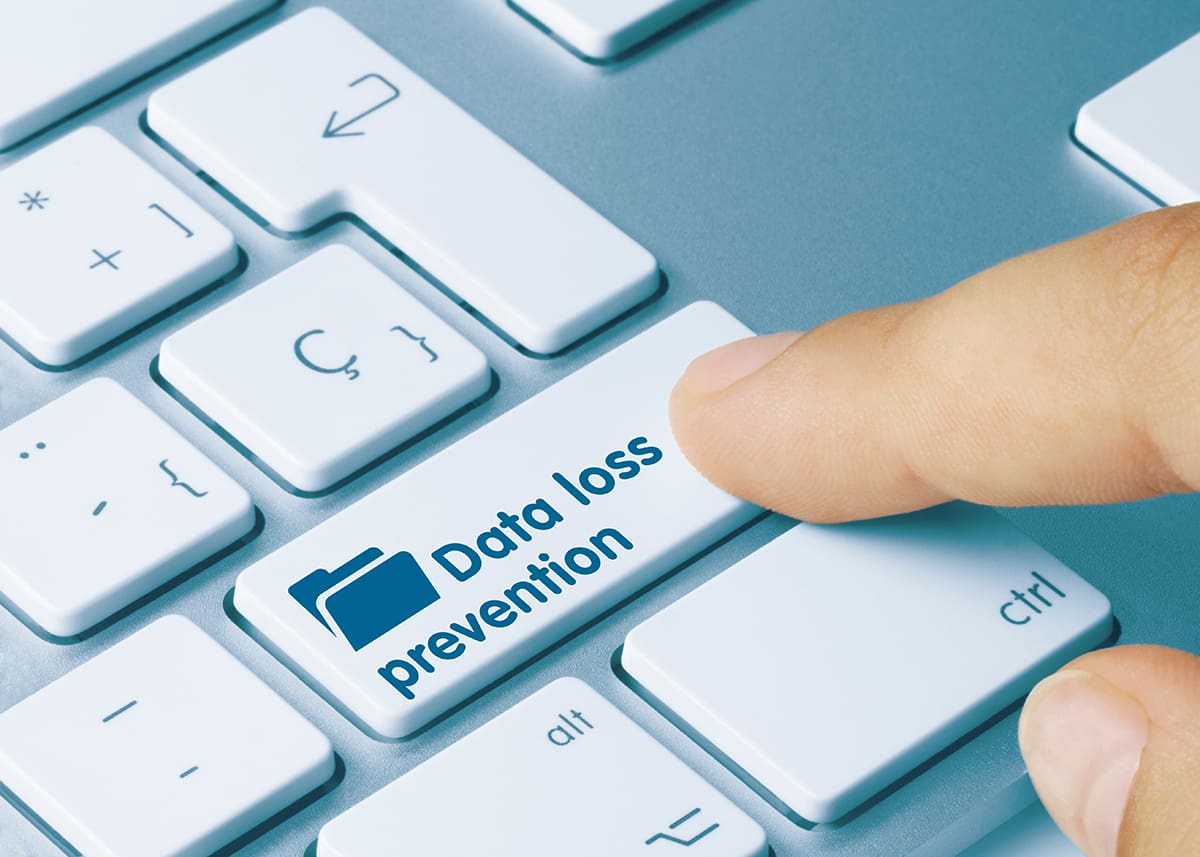 A finger pressing a button on a keyboard that reads “Data Loss Prevention.”