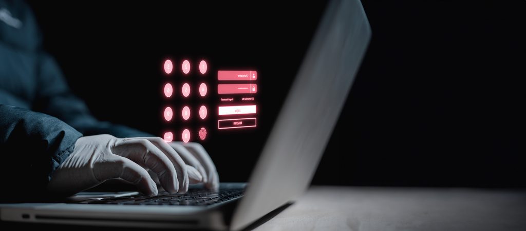 A cybercriminal wearing gloves and typing on a computer, trying to guess passwords.