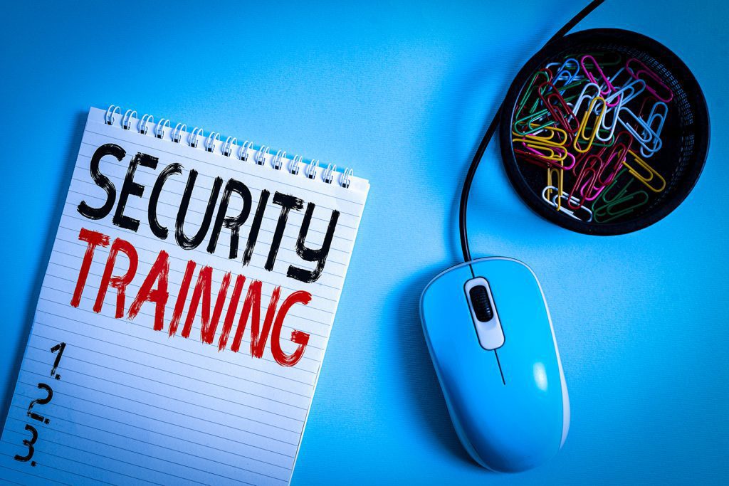 A notepad with the words “Security Training” printed on top. It’s next to a computer mouse and a cup of paperclips.