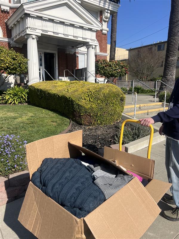 A PC Professional team member dropping off boxes of clothes at a non-profit
