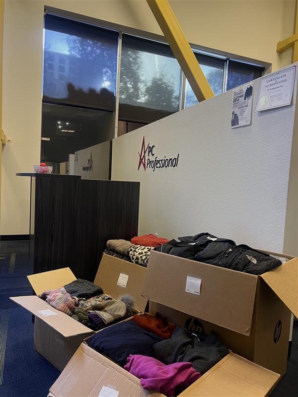 4 Boxes packed full of winter clothing items, positioned in front of the PC Professional logo.